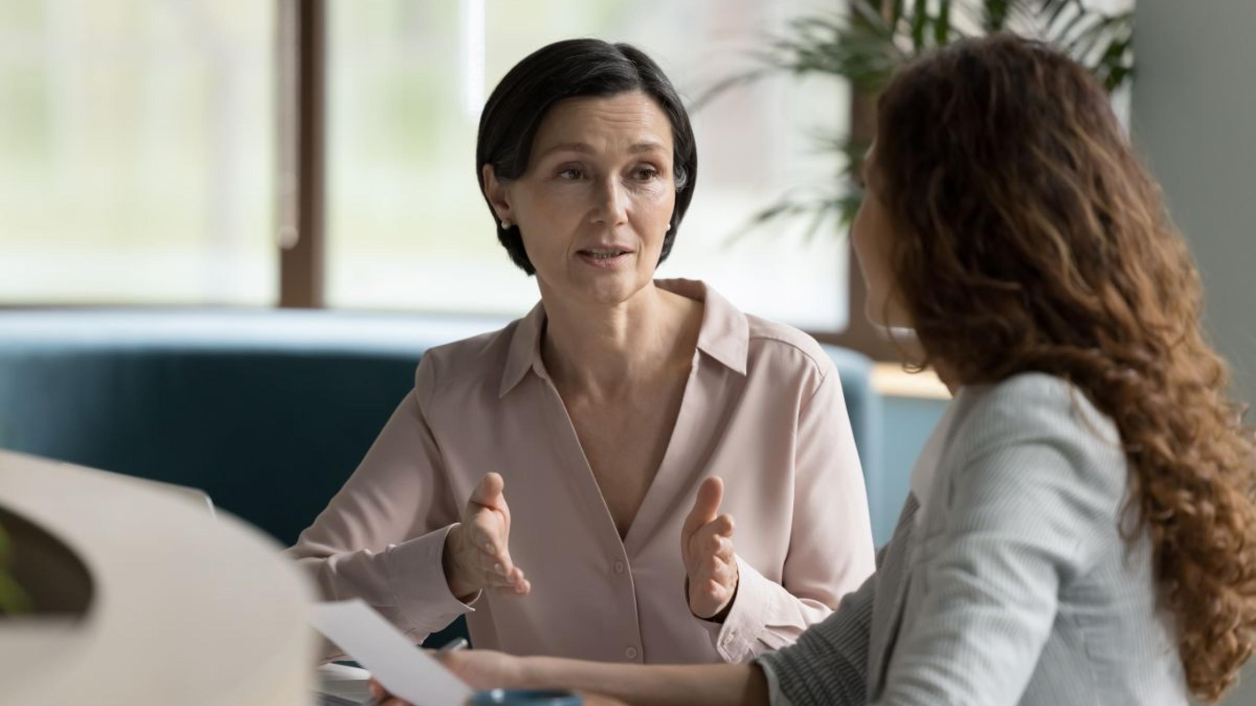 Twee vrouwen op kantoor in gesprek.