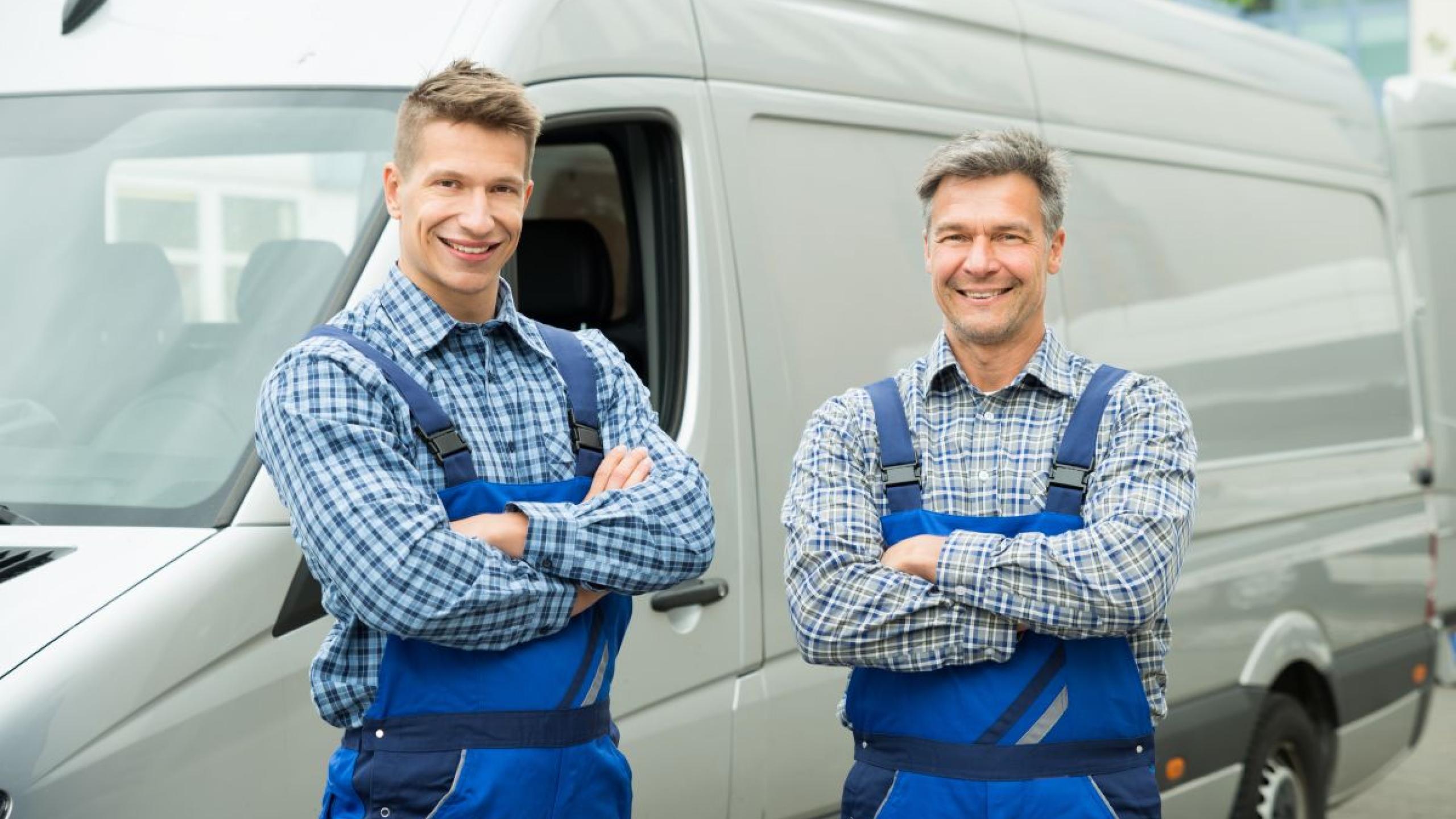 Twee technici naast grijze bestelwagen.